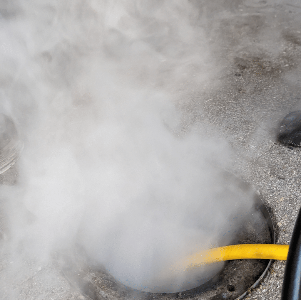 Smoke test with smoke coming out of drain